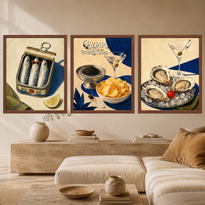 May include: A set of three framed wall art prints. The first shows a tin of sardines with one wearing red sunglasses and a lemon wedge. The second features a bowl of potato chips, caviar, and a martini. The third displays oysters on ice.