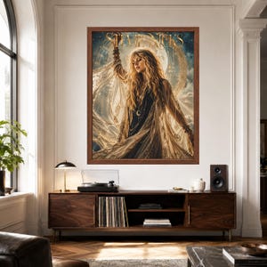 May include: A framed wall art print featuring a portrait of Stevie Nicks with long blonde hair, wearing a dark top and a flowing sheer shawl. The background displays a large moon and celestial elements. The name Stevie Nicks is printed in gold.