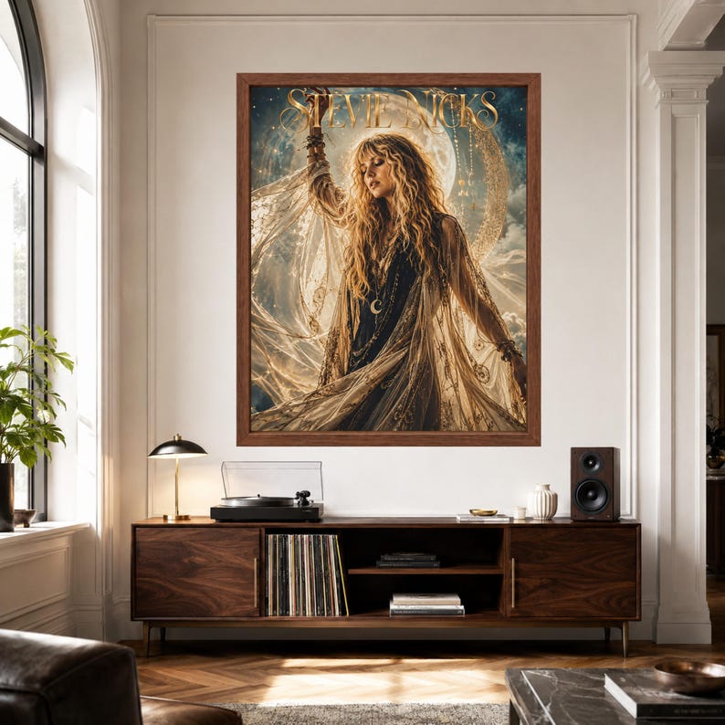 May include: A framed wall art print featuring a portrait of Stevie Nicks with long blonde hair, wearing a dark top and a flowing sheer shawl. The background displays a large moon and celestial elements. The name Stevie Nicks is printed in gold.