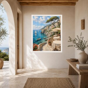 Pu&ograve; includere: Una stampa artistica incorniciata raffigurante una scena costiera mediterranea con mare turchese, barche a vela e un villaggio sulla scogliera. Il primo piano mostra una terrazza in pietra con tavoli rotondi, sedie e fiori in vaso.