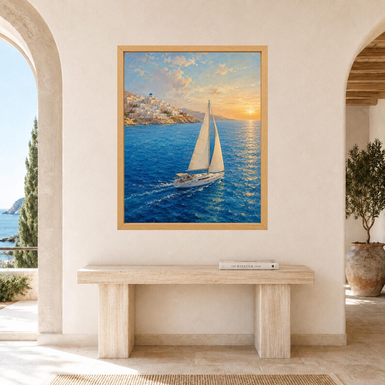 May include: A framed wall art print featuring a sailboat with white sails navigating deep blue waters at sunset. In the background, a coastal town with white buildings sits on a hillside under a soft, golden sky with scattered clouds.