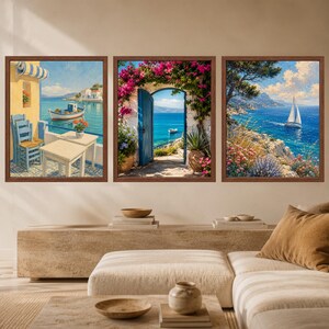 May include: A set of three framed wall art prints featuring Mediterranean coastal scenes. The left print shows a seaside patio with chairs and a boat, the centre depicts a blue door framed by pink flowers, and the right shows a sailboat on the sea.