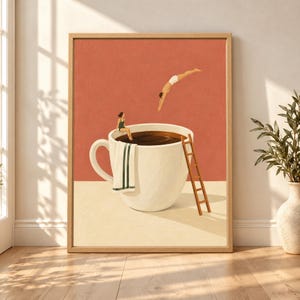 Framed surreal coffee wall art showing a giant cream coffee cup used as a swimming pool with a tiny woman sitting on the rim, another diver jumping in and a small wooden ladder against a terracotta background.