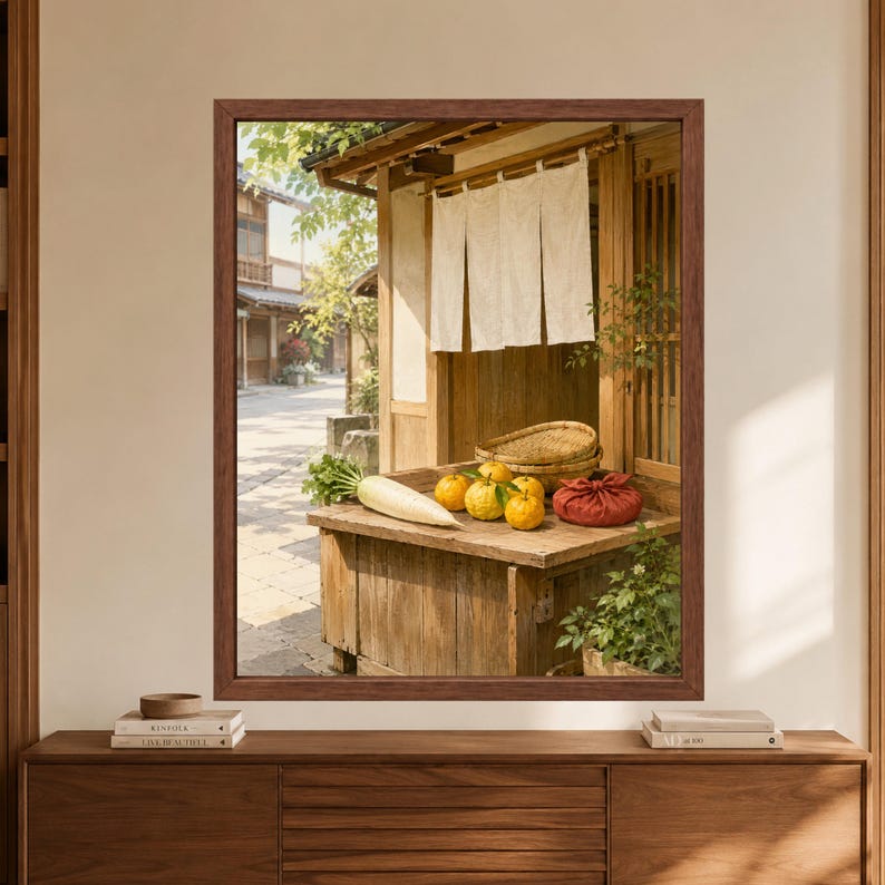 Framed Japanese market wall art showing yuzu citrus, a white daikon radish, woven baskets and a red cloth bundle on a rustic wooden storefront beneath cream noren curtains.