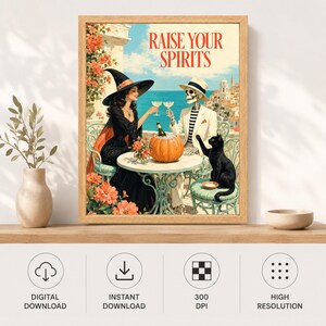 May include: A framed wall art print titled RAISE YOUR SPIRITS featuring a witch in a black dress and a skeleton in a white suit sitting at a table with a pumpkin, a black cat, and glasses of wine against a coastal Mediterranean backdrop.