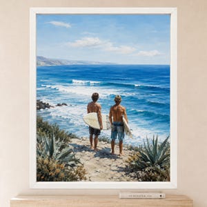 Puede incluir: Una l&aacute;mina de arte enmarcada que muestra a dos personas de pie en un acantilado costero frente a un oc&eacute;ano azul con olas. Cada persona sostiene una tabla de surf y lleva ba&ntilde;ador. El primer plano presenta plantas de agave verde bajo un cielo despejado.