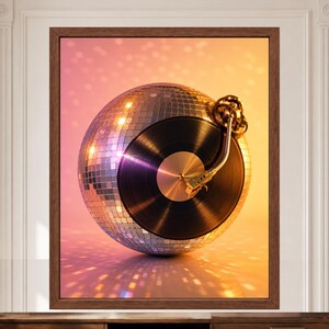 Puede incluir: Una impresi&oacute;n de arte mural enmarcada que muestra una bola de discoteca esf&eacute;rica con un disco de vinilo negro integrado en el centro. Un brazo de tocadiscos dorado descansa sobre el disco. La composici&oacute;n tiene un fondo degradado rosa y naranja.