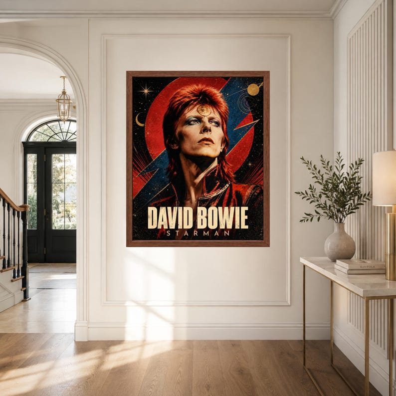 May include: A framed rectangular wall poster featuring a portrait of David Bowie with red hair, set against a dark background with a large red circle, a blue lightning bolt, and celestial elements. The text DAVID BOWIE STARMAN is printed below.