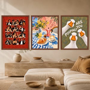May include: A set of three framed wall art prints. The left print features a red grid of twelve illustrations of people dining. The center print shows a Mediterranean breakfast scene with a croissant, coffee, and flowers. The right print depicts three white geese with the text "ARE YOU POOPING?"