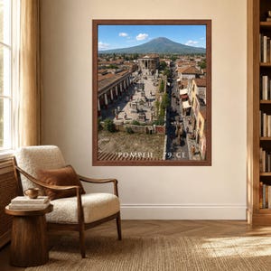 K&ouml;nnte beinhalten: Ein gerahmter Wandkunstdruck, der eine historische Rekonstruktion von Pompeji im Jahr 79 n. Chr. zeigt, mit einem zentralen Tempel, gepflasterten Stra&szlig;en und dem Vesuv im Hintergrund unter blauem Himmel, mit dem Text POMPEII 79 CE unten.