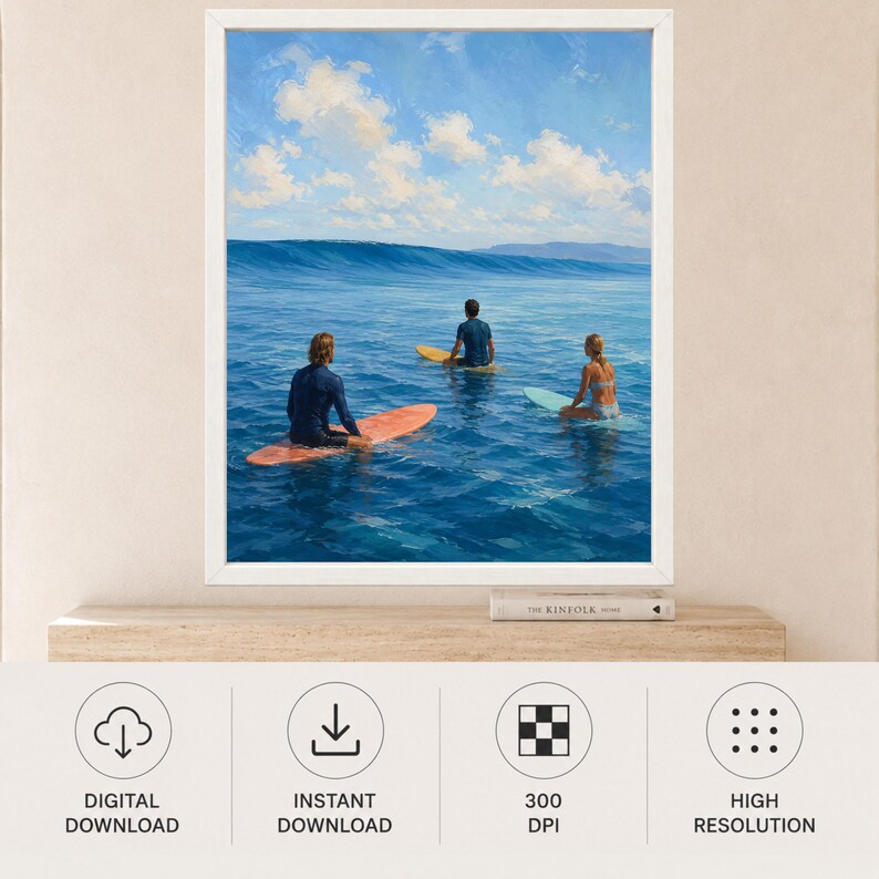 May include: A framed wall art print depicting three individuals on surfboards in the ocean. One person sits on an orange surfboard, another on a yellow board, and the third on a light blue board. The scene features deep blue water and a bright sky.