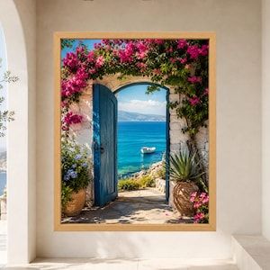 Framed Greek island wall art showing an open blue wooden door in a whitewashed stone arch covered with pink bougainvillea, overlooking turquoise Aegean water and a small white boat.