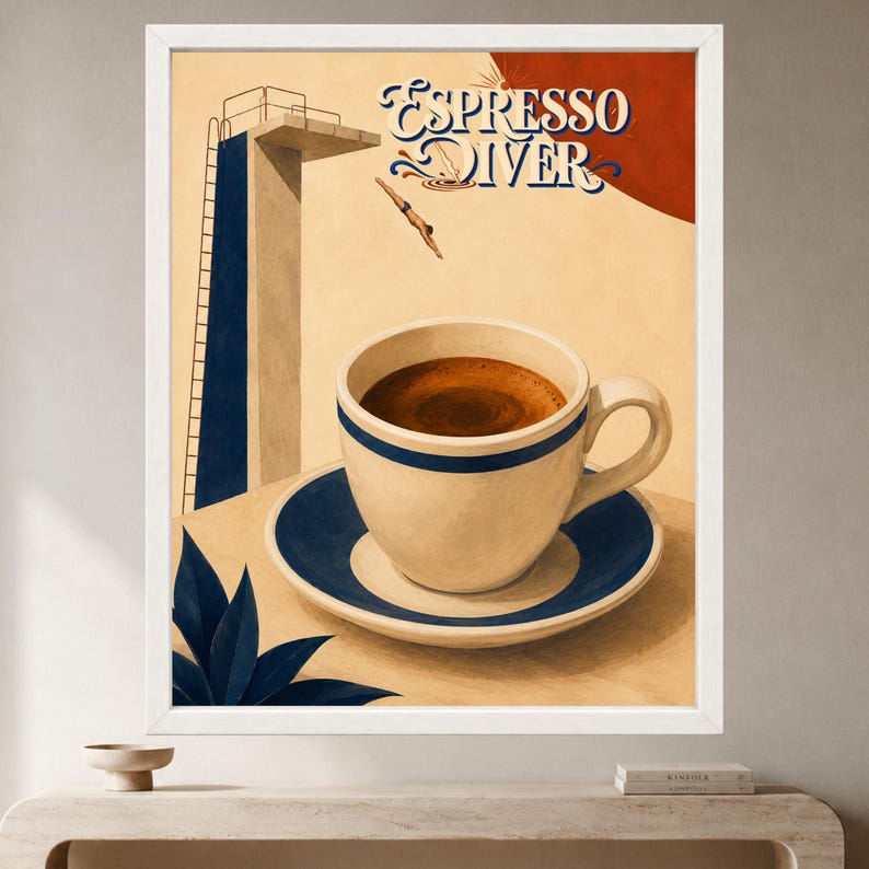 May include: A framed wall art print titled Espresso Diver featuring a white coffee cup with a blue stripe on a matching saucer. The background shows a tall blue diving board, a diver mid-air, and a large red sun against a cream-colored backdrop.
