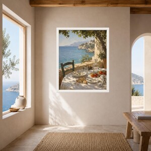 May include: A framed wall art print depicting a coastal scene with a round table set for a meal on a terrace overlooking the blue sea. The table features plates, a glass bottle, and tomatoes, all shaded by tree branches under a bright sky.