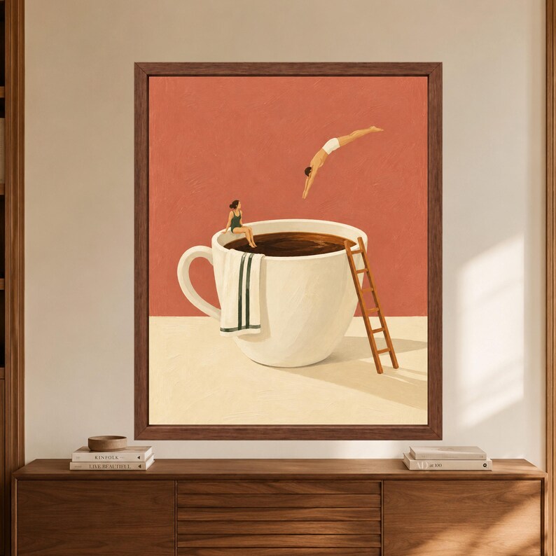 May include: A framed wall art print featuring a large white coffee cup filled with dark liquid. A person in a green swimsuit sits on the rim with a white towel, while another person in white shorts dives into the coffee. A wooden ladder leans against the cup.