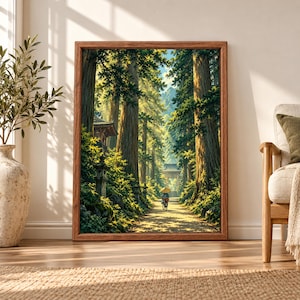 Framed Japanese forest wall art showing a sunlit cedar tree path with stone lanterns, traditional temple architecture and a lone cyclist beneath a parasol.