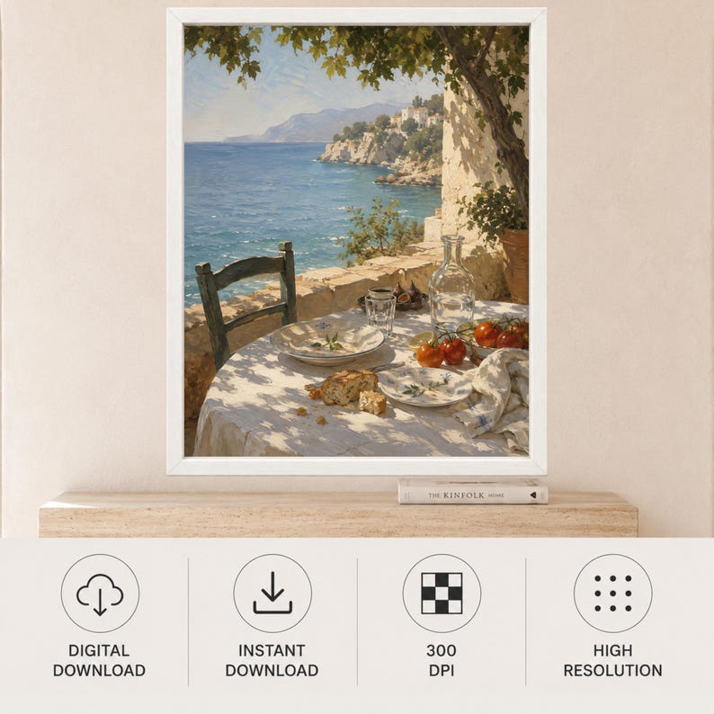 May include: A framed wall art print depicting a coastal scene with a table set for a meal on a terrace. The table features a white cloth, plates, a glass carafe, fresh tomatoes, and bread. A dark wooden chair sits beside the table under a tree.