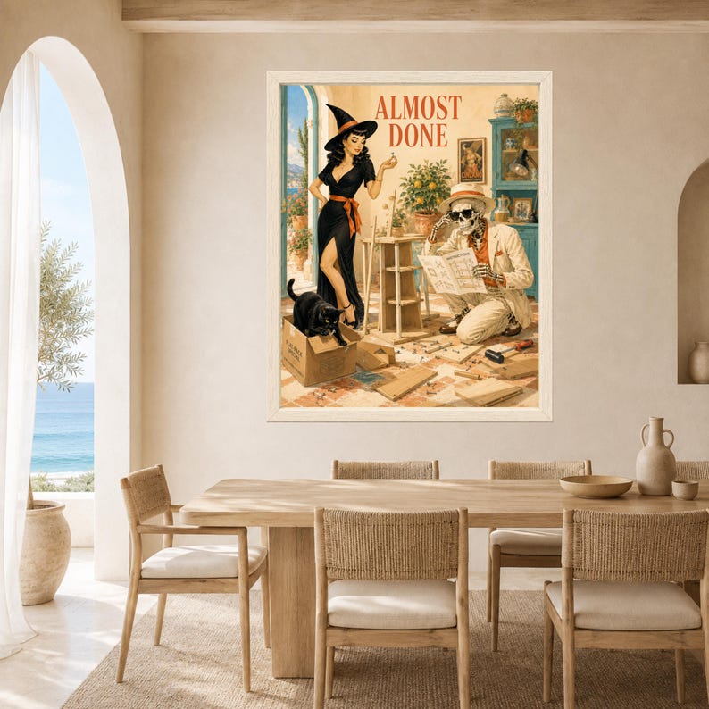 May include: A framed wall art print titled ALMOST DONE featuring a retro-style illustration of a person in a black dress and witch hat, a skeleton in a beige suit reading blueprints, and a black cat in a cardboard box on a tiled floor.