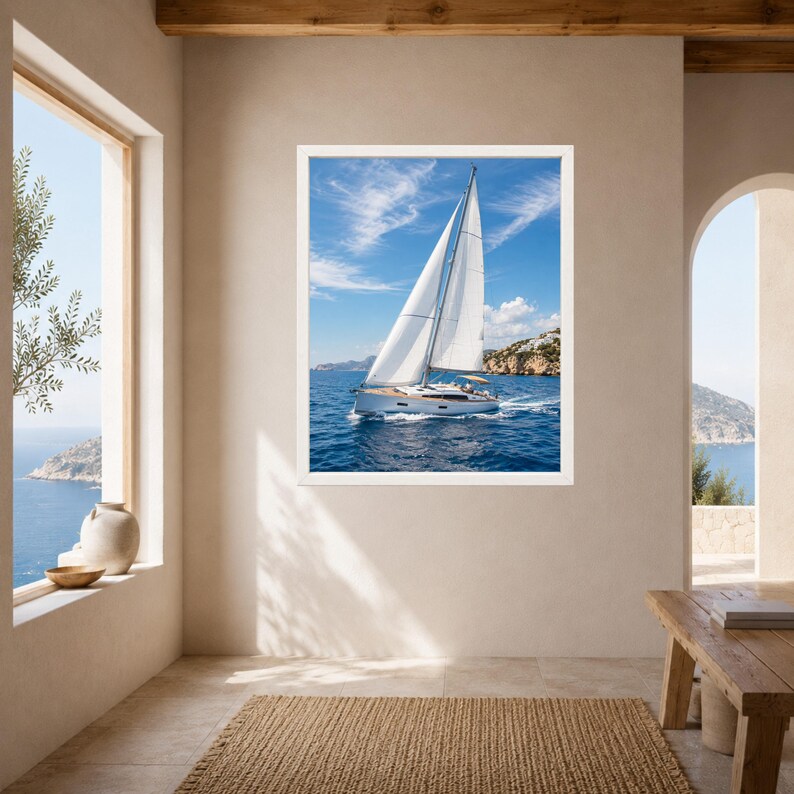 Puede incluir: Una impresi&oacute;n de arte mural enmarcada que muestra un velero blanco con las velas desplegadas navegando en aguas oce&aacute;nicas de color azul profundo bajo un cielo brillante con nubes tenues, con una costa rocosa visible a lo lejos, en alta resoluci&oacute;n.