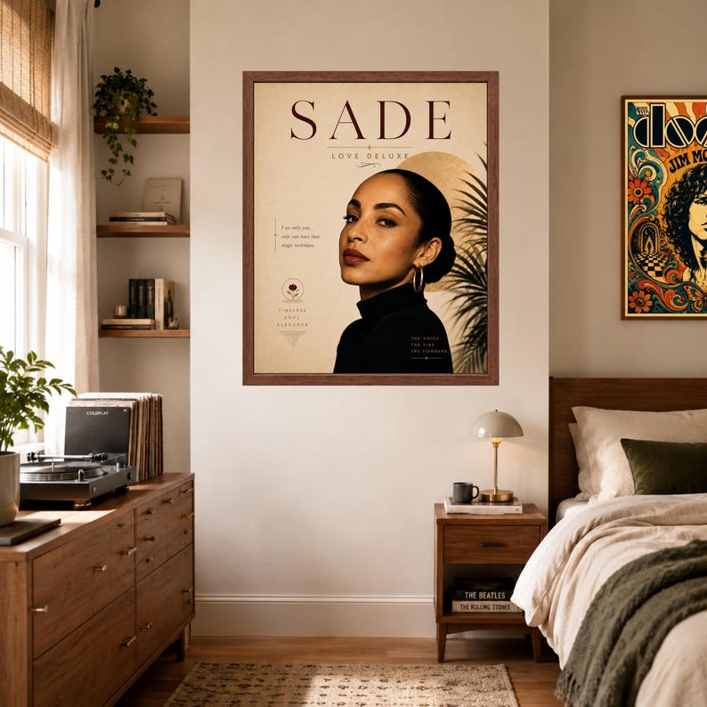 May include: A framed wall poster featuring a portrait of Sade with the text SADE LOVE DELUXE. The design includes a beige background, a golden sun graphic, palm frond silhouettes, and small text elements including the phrase TIMELESS SOUL ELEGANCE.