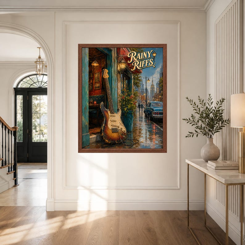 Puede incluir: Una impresi&oacute;n art&iacute;stica enmarcada titulada Rainy Riffs que muestra una guitarra el&eacute;ctrica sunburst apoyada contra una puerta en una calle urbana lluviosa con un coche azul, pavimento mojado y edificios bajo un cielo oscuro.