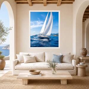 Op de afbeelding: Een ingelijste wandkunstprint met een zeilboot met witte zeilen die over diepblauw oceaanwater vaart onder een heldere lucht. Het vaartuig is in beweging vastgelegd, waardoor een kielzog ontstaat, met verre kustbergen aan de horizon.