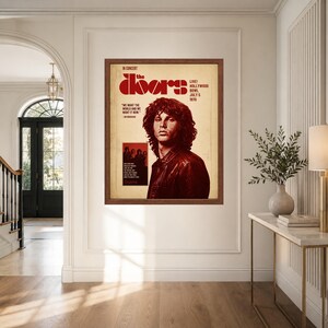 Pu&ograve; includere: Un poster incorniciato con un ritratto di Jim Morrison in una giacca di pelle scura. Il testo recita The Doors, In Concert, Live! Hollywood Bowl July 5 1970 e We Want The World And We Want It Now. Il poster ha un'estetica di carta invecchiata.