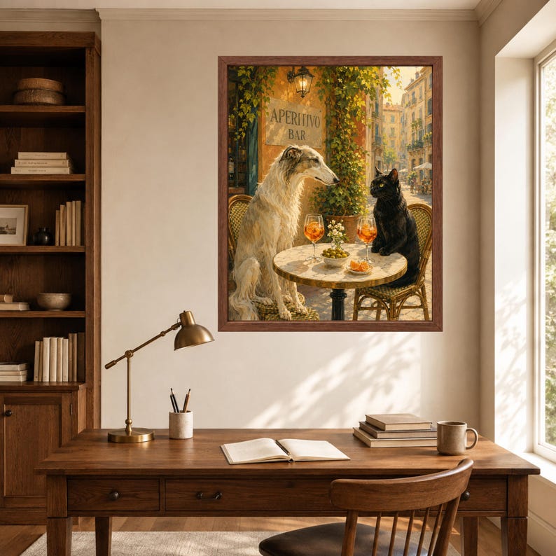 May include: A framed wall art print depicting a white Borzoi dog and a black cat sitting at a round outdoor table. The table holds two glasses of orange liquid and a small bowl of snacks. A sign on the wall behind them reads APERITIVO BAR.