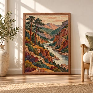 Framed vintage mountain landscape wall art showing a winding river through pine-covered canyon cliffs, layered mountains and warm rust, green and ochre foliage.