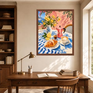 May include: A framed wall art print depicting a sunny outdoor breakfast scene with a croissant, a cup of coffee, a moka pot, a vase of yellow flowers, and a lemon on a blue and white checkered tablecloth, set against a pink wall and blue sea.