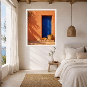 Pu&ograve; includere: Una stampa d'arte da parete incorniciata raffigurante una vivace parete in stucco arancione con una porta in legno blu intenso. Un gatto arancione riposa sul gradino in pietra accanto a un cesto intrecciato pieno di limoni gialli. Ombre di rami.