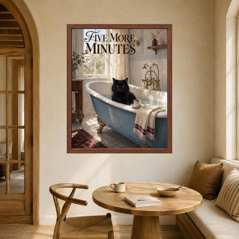 May include: A framed wall art print featuring a black cat sitting in a blue clawfoot bathtub filled with water. The text 'FIVE MORE MINUTES' is printed at the top. A white towel hangs over the edge of the tub next to a small cup and saucer.