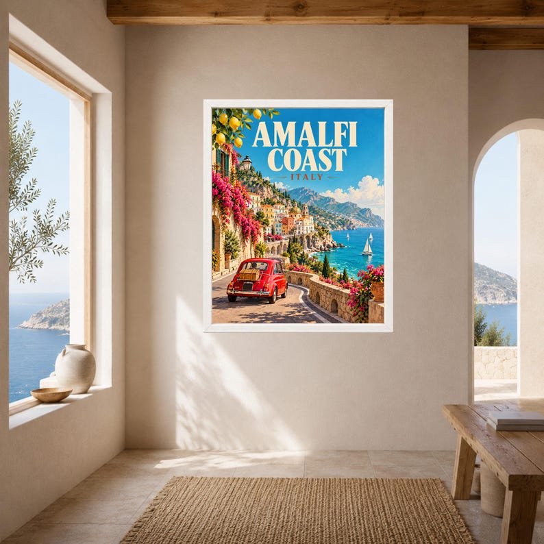 May include: A framed travel poster featuring the Amalfi Coast in Italy, displaying a red vintage car on a coastal road, vibrant pink bougainvillea, lemon trees, and sailboats on the blue sea, with the text AMALFI COAST ITALY at the top.