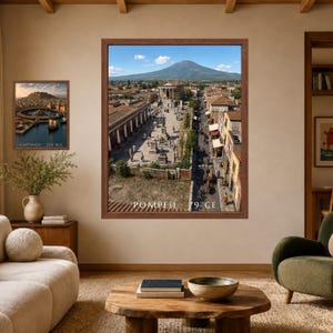 K&ouml;nnte beinhalten: Ein gro&szlig;er gerahmter Wandkunstdruck, der eine historische Rekonstruktion von Pompeji im Jahr 79 n. Chr. zeigt, mit einem zentralen Forum, Steingeb&auml;uden und einem Berg im Hintergrund. Ein kleinerer Druck zeigt Karthago 220 v. Chr. mit Hafen.
