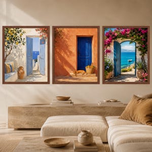 Pu&ograve; includere: Un set di tre stampe da parete incorniciate raffiguranti scene mediterranee. A sinistra un albero di limoni e una porta blu, al centro una parete arancione con porta blu e un gatto, a destra una porta blu incorniciata da bouganville rosa.