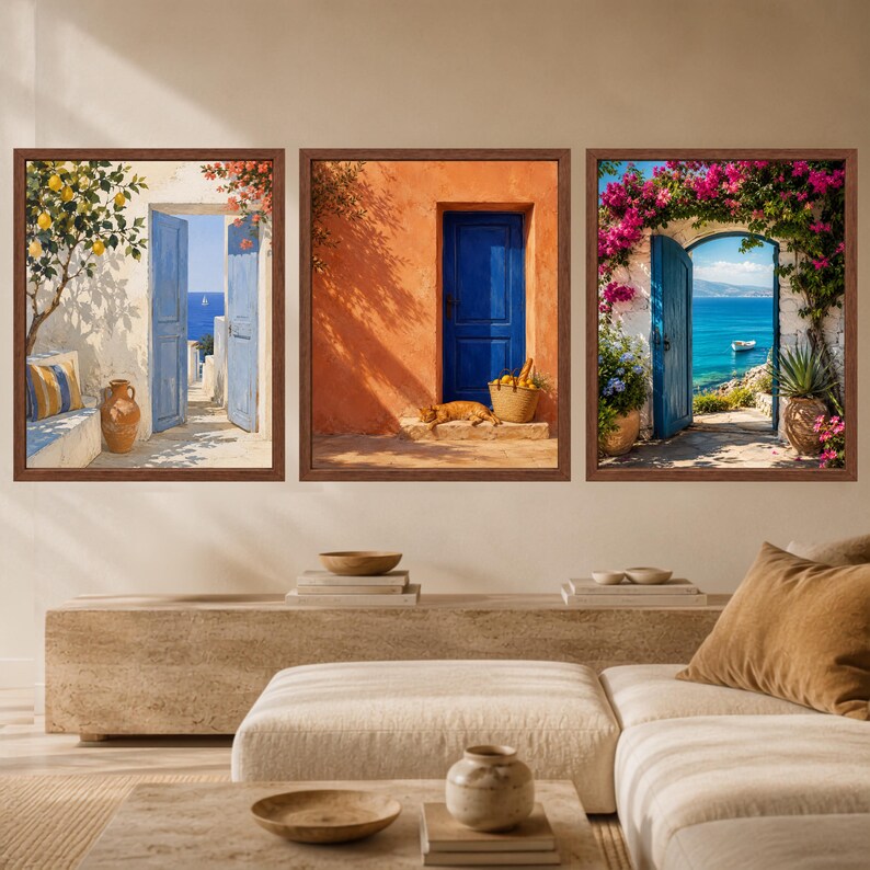 Pu&ograve; includere: Un set di tre stampe da parete incorniciate raffiguranti scene mediterranee. A sinistra un albero di limoni e una porta blu, al centro una parete arancione con porta blu e un gatto, a destra una porta blu incorniciata da bouganville rosa.