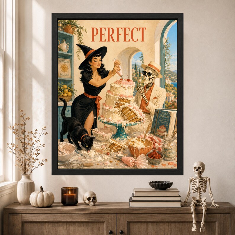 May include: A framed wall art print titled PERFECT featuring a black-haired witch in a black dress decorating a multi-tiered cake. A black cat stands nearby, while a skeleton wearing a hat and sunglasses watches. The scene includes baking tools.