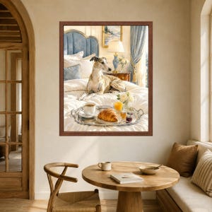 May include: A framed wall art print depicting a brindle whippet resting on a white bed with a blue headboard. A silver tray on the bed holds a cup of coffee, a croissant, a glass of orange juice, and a small jar of jam near a bedside lamp.