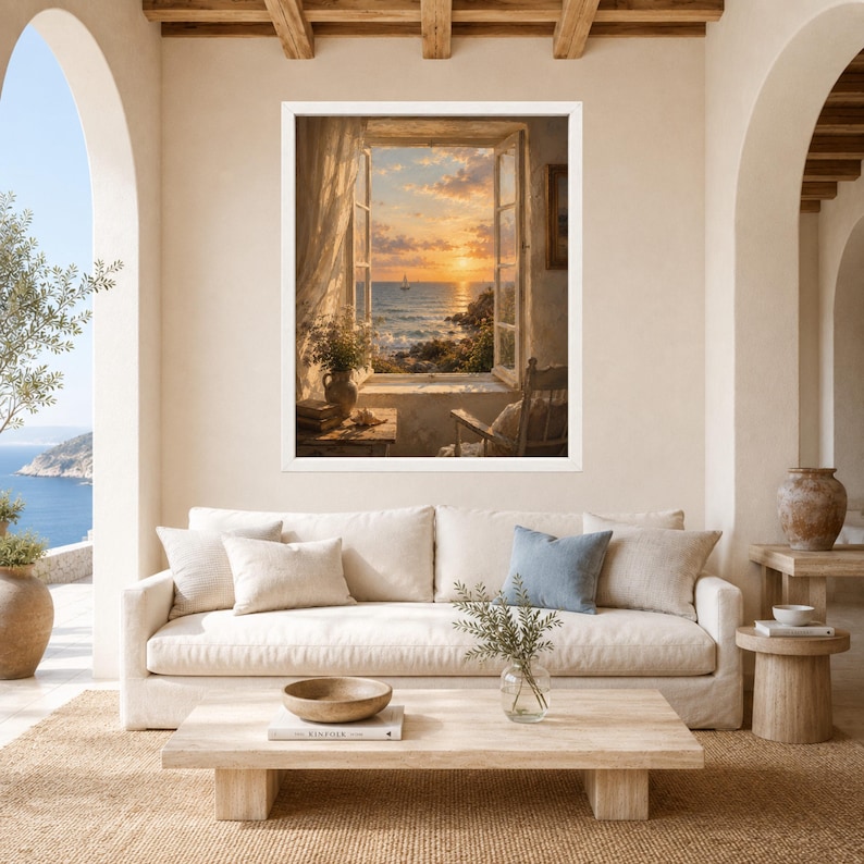 May include: A framed wall art print depicting an open window view of a sunset over the ocean. The scene shows a calm sea, a distant sailboat, and a rocky coastline. Inside the window, a wooden chair, a vase with greenery, and books are visible.