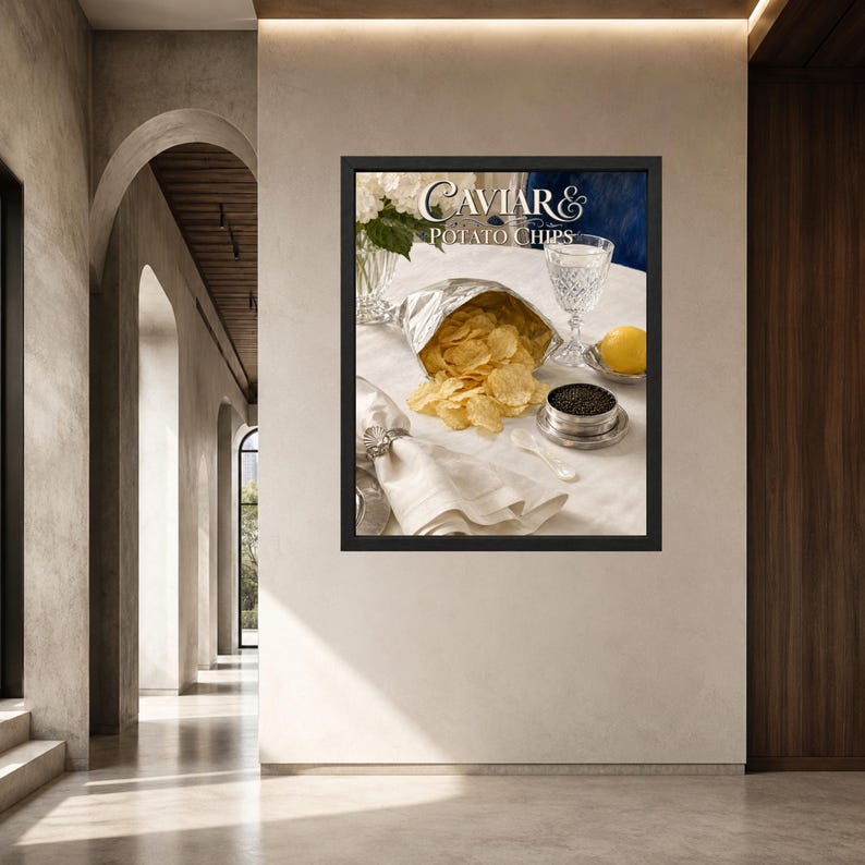 May include: A framed wall art print titled Caviar & Potato Chips featuring a silver bag of golden potato chips, a small metal tin of black caviar, a crystal glass, a lemon, and a white napkin with a shell napkin ring on a white tablecloth.