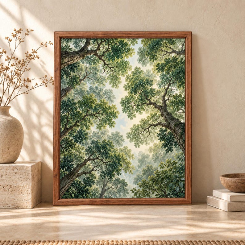 Framed forest canopy wall art showing an upward view through tall mature trees with twisting trunks, layered green leaves and a softly illuminated opening in the sky.