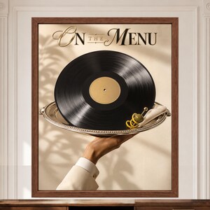 May include: A framed wall art print featuring a black vinyl record served on a silver platter with a green olive garnish. The text "On the Menu" is printed in elegant gold lettering at the top. The composition is set against a neutral background.