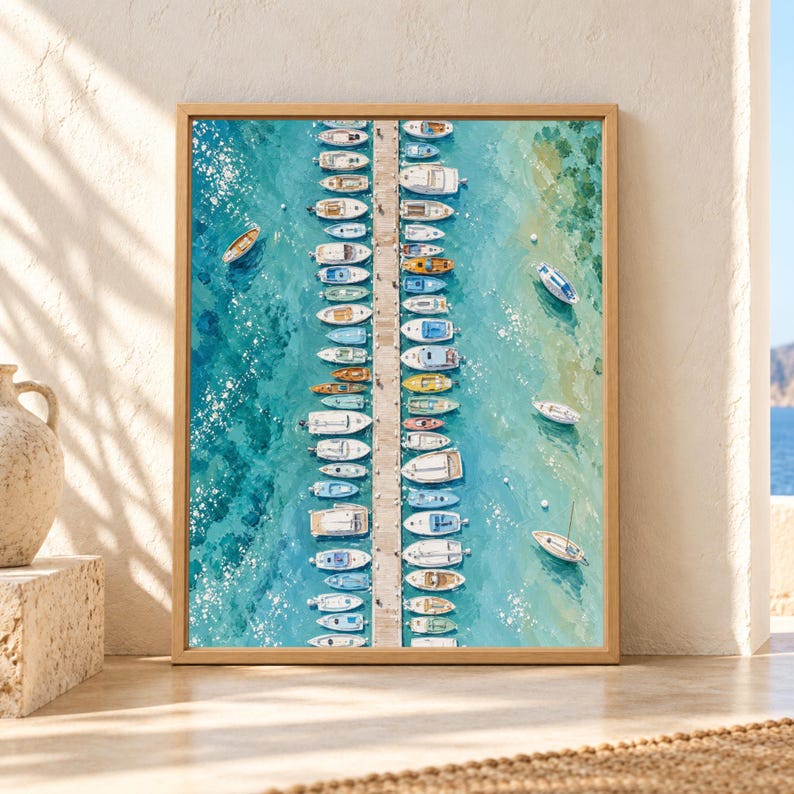 Framed aerial marina wall art showing rows of small boats docked along a long central pier in clear turquoise and aqua water with bright Mediterranean coastal colors.