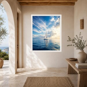 Pode incluir: Uma impress&atilde;o de arte de parede emoldurada apresentando um veleiro branco em um oceano azul calmo sob um c&eacute;u brilhante com nuvens leves. A cena captura a embarca&ccedil;&atilde;o centralizada na &aacute;gua, refletindo a luz do sol em um dia claro.