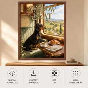 以下が含まれることがあります： 「Window Seat」と題された額入りウォールアートプリント。緑色の布張り列車座席に座る黒と茶色のダックスフントが描かれ、窓の外には風景が広がり、テーブルの上にはクロワッサン、コーヒーカップ、新聞が置かれています。