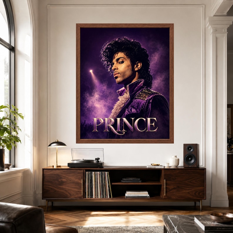 May include: A framed wall art print featuring a portrait of the musician Prince in a purple jacket with a ruffled collar, set against a dark purple smoky background with a spotlight. The name PRINCE is printed in large gold letters at the bottom.
