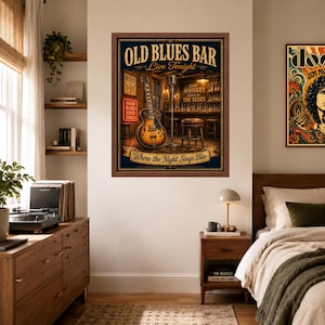 Op de afbeelding: Een ingelijste rechthoekige wandkunstprint getiteld Old Blues Bar, met een vintage-stijl illustratie van een elektrische gitaar, een microfoonstandaard en een barkruk in een taverne met de tekst Where the Night Sings Blue.