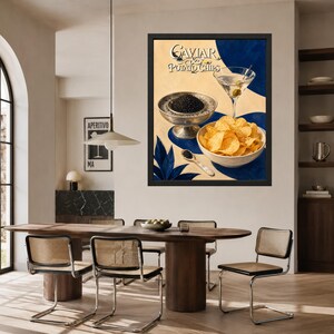 May include: A framed wall art print featuring the text Caviar & Potato Chips, displaying a silver bowl of black caviar, a bowl of golden potato chips, a martini glass with an olive, and a small spoon, set against a cream and blue background.