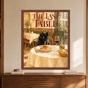 Framed black cat pasta wall art showing a black cat eating spaghetti alone at an elegant Italian restaurant table with red wine, bread and olive oil beneath The Last Table lettering.