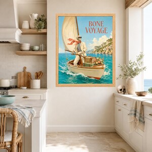 May include: A framed wall art print featuring a skeleton wearing sunglasses, a white suit, and a red scarf, steering a sailboat on blue water. The text BONE VOYAGE is printed in red above the skeleton. Luggage and flowers sit in the boat.